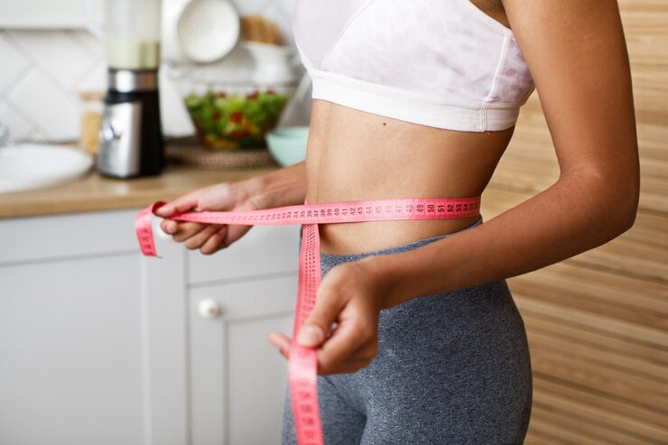 african woman is measuring her waist with centimeter 8353 10008 african woman is measuring her waist with centimeter 8353 10008